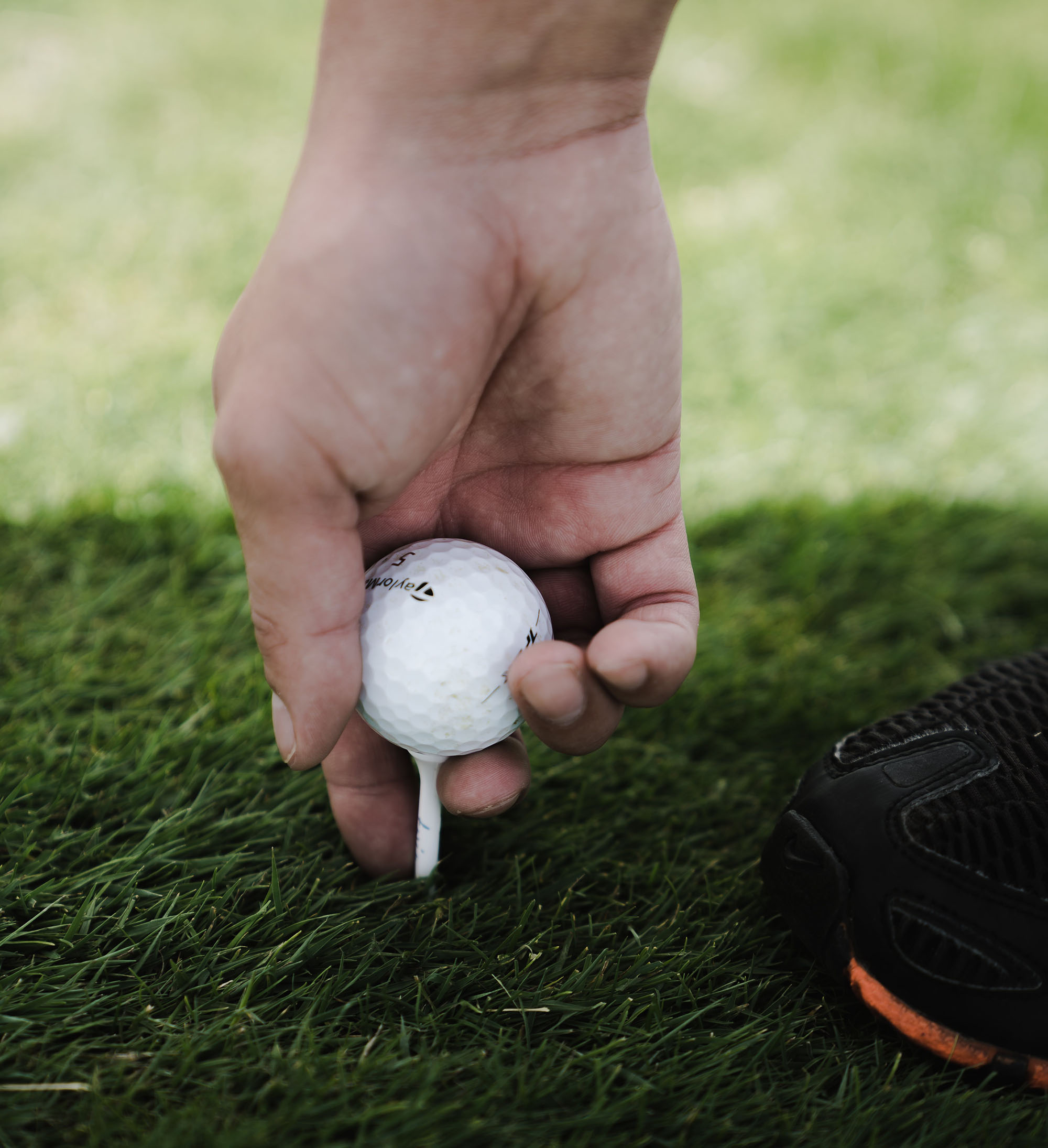 Person placing ball on a tee